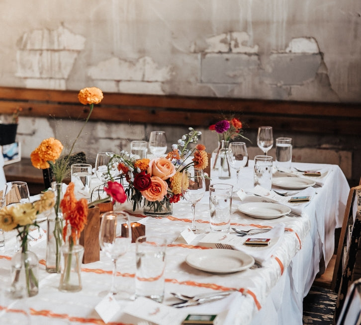wedding reception table featuring orange organic flower arrangements by Bagel's Florals in New Mexico