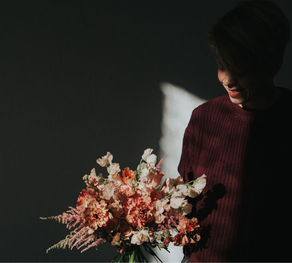 portrait of Bagel in shadow holding a coral floral design in Albuquerque New Mexico